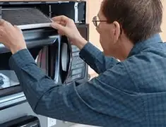 Appliance repair technician replacing a microwave vent filter in Henderson, NV