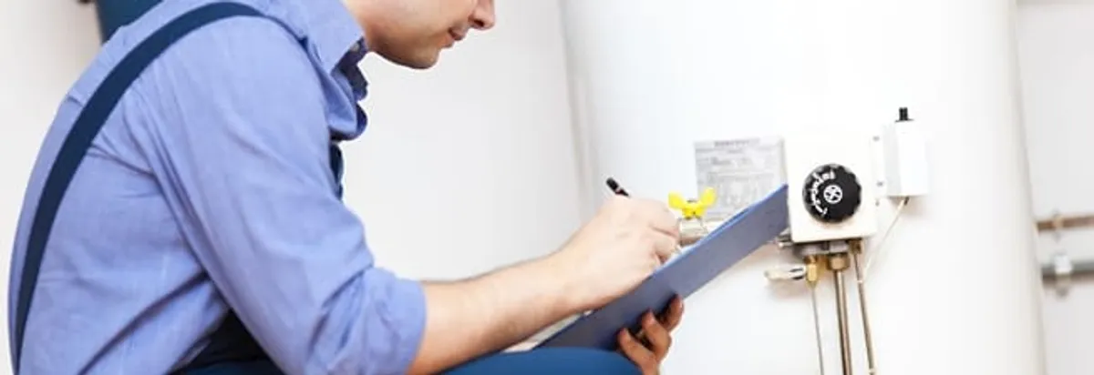 Water heater repair technician inspecting the unit and recording service notes in Henderson, NV